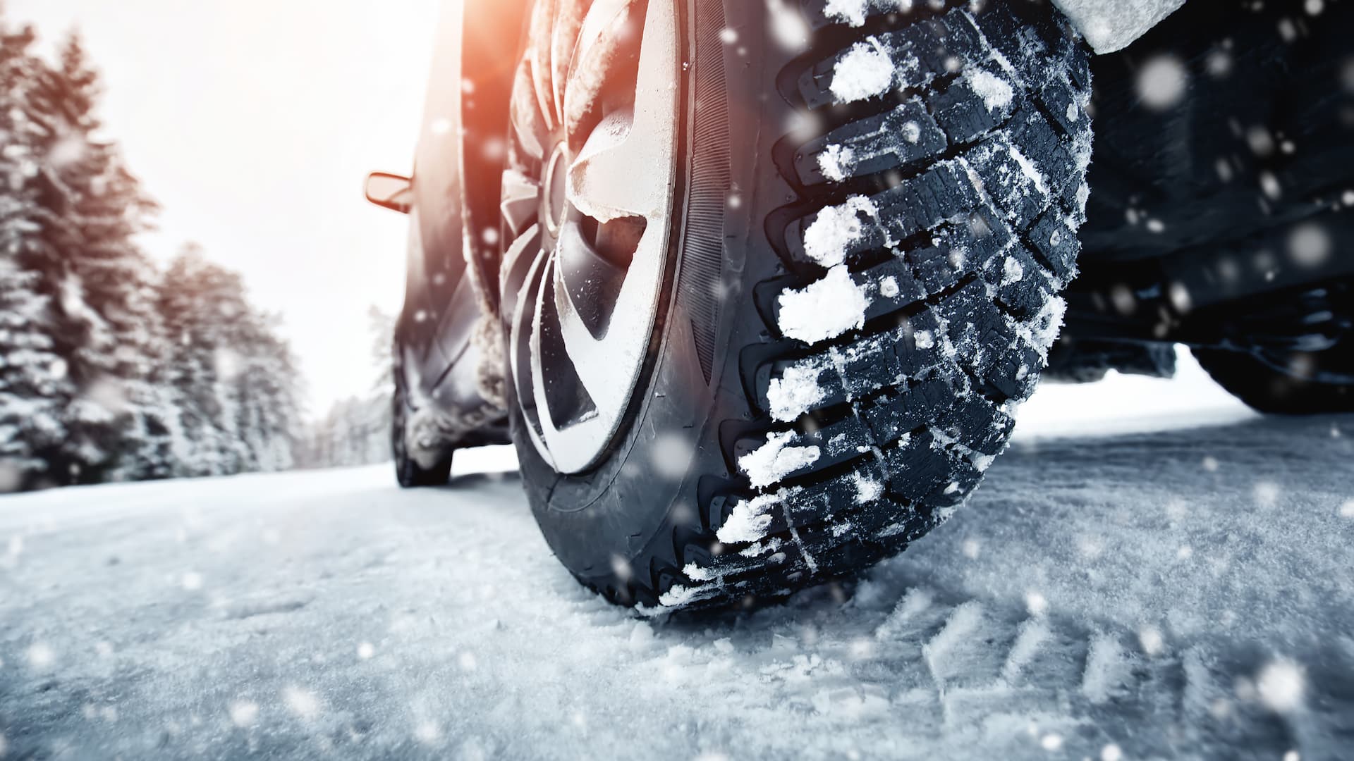 Image d'une voiture en train de freiner sur de la glace, avec de la neige et de la glace projetées par les pneus.