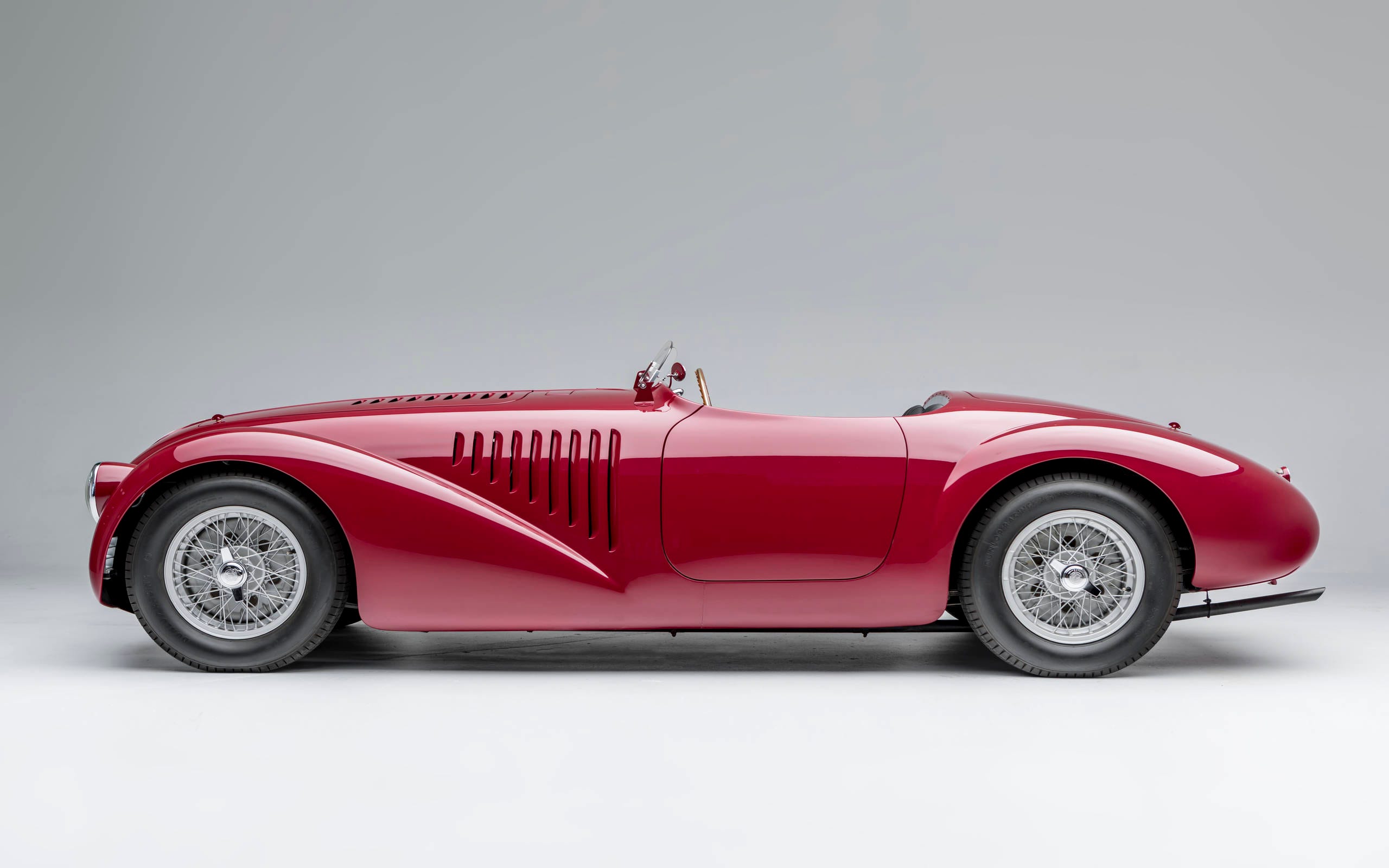Vue latérale d'une Ferrari classique rouge, symbole de l'héritage de la marque.