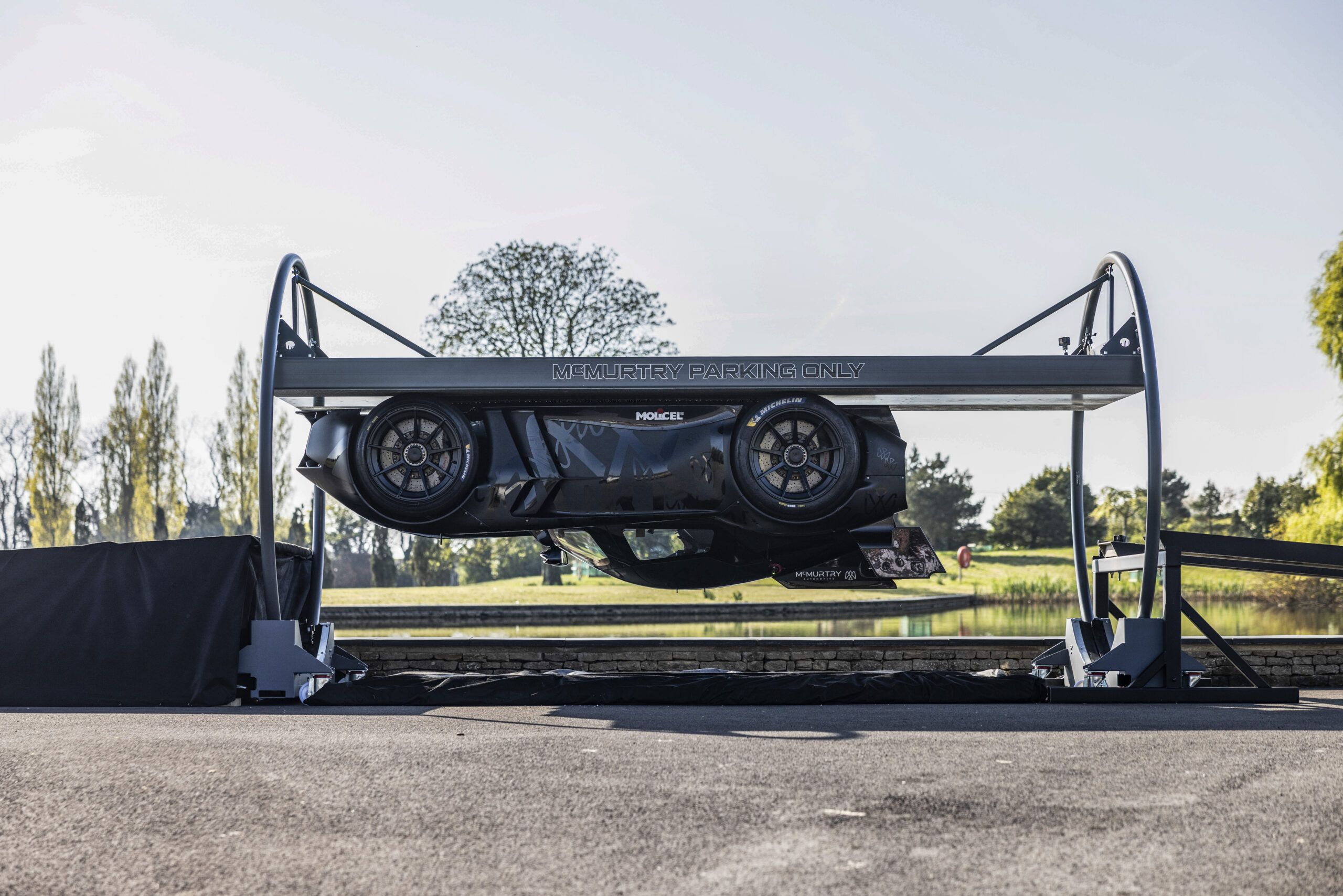 Une voiture futuriste roulant tête en bas sur une piste métallique, maintenue par des forces magnétiques.