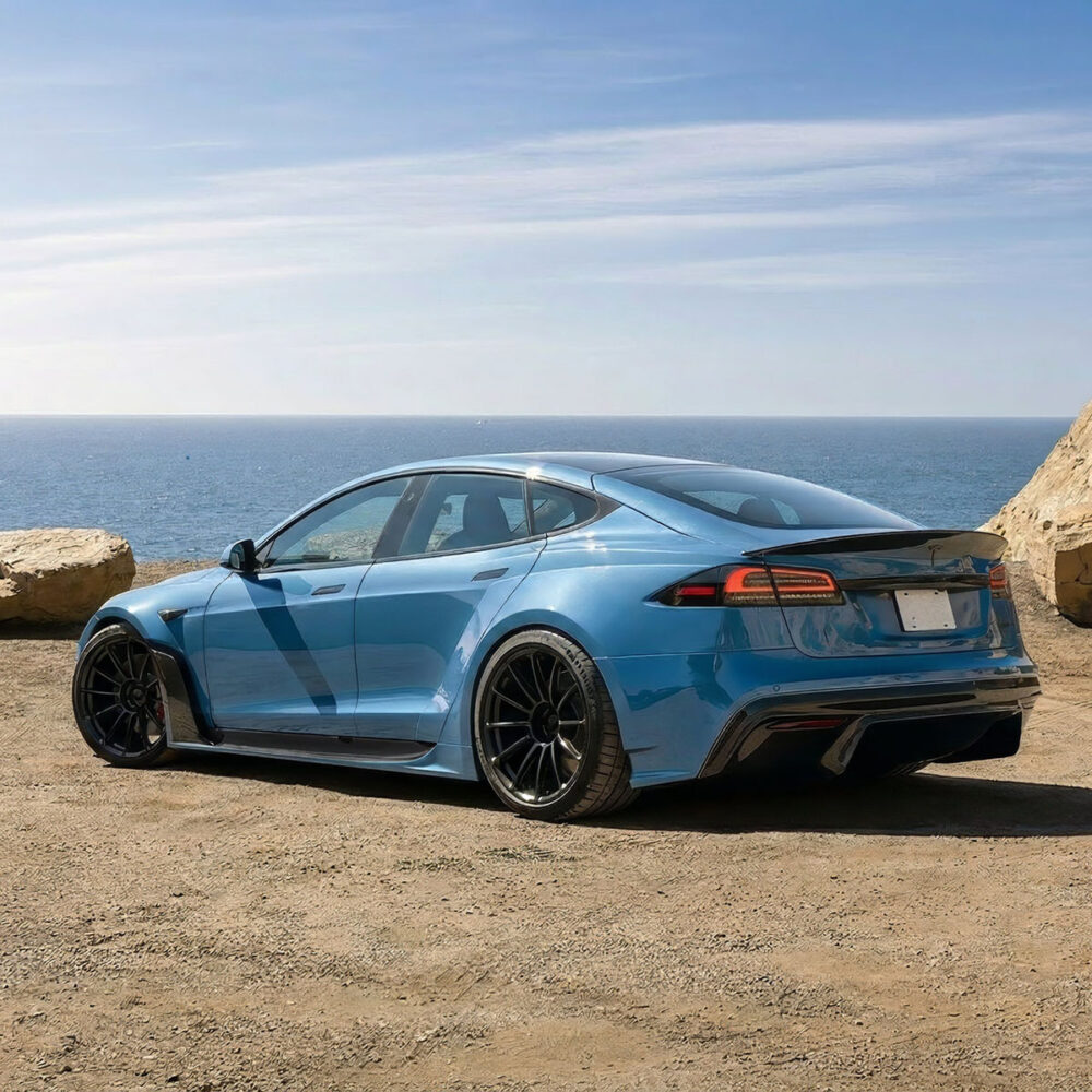 Vue latérale d'une Tesla Model S Plaid modifiée avec un kit carrosserie large, des jantes noires et une peinture bleu mat.